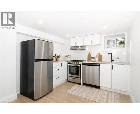 A modern kitchen with a stainless steel refrigerator, oven, and microwave.