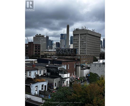 A cityscape with a mix of modern and older buildings under a cloudy sky.