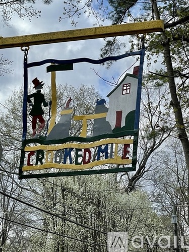 A sign for a Crooked Mile is hanging from a metal pole.