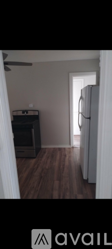 A room with wooden flooring and a white door.