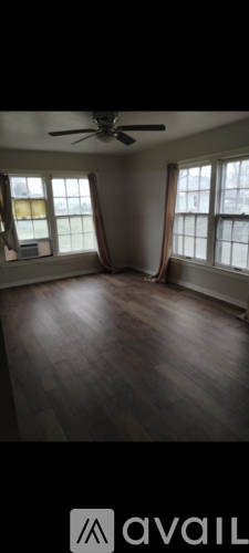 A room with wooden floors and a ceiling fan.