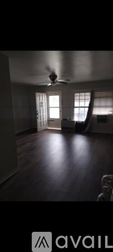 A room with wooden floors and a ceiling fan.