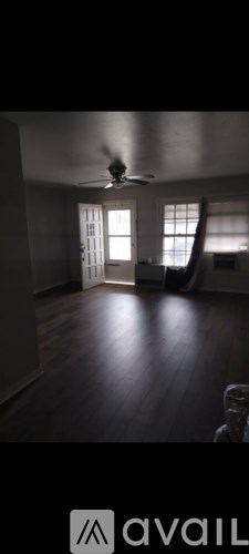 A room with wooden floors and a ceiling fan.