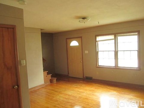 A room with a wooden floor and a window.