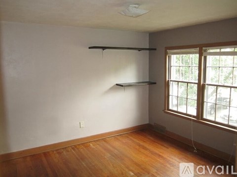 Empty room with a window and a wooden floor.