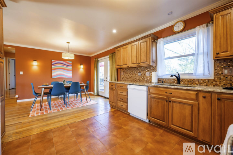A kitchen with wooden cabinets and a dining table with chairs.