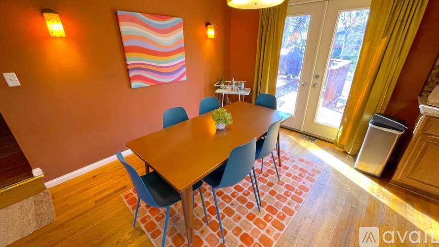 A dining room with a wooden table and blue chairs.