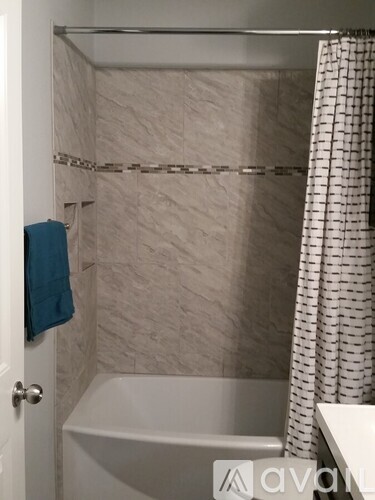 A white bathroom with a white tub and a white shower curtain.