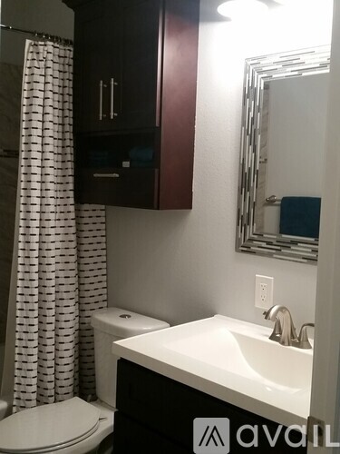 A bathroom with a white sink and a white toilet.