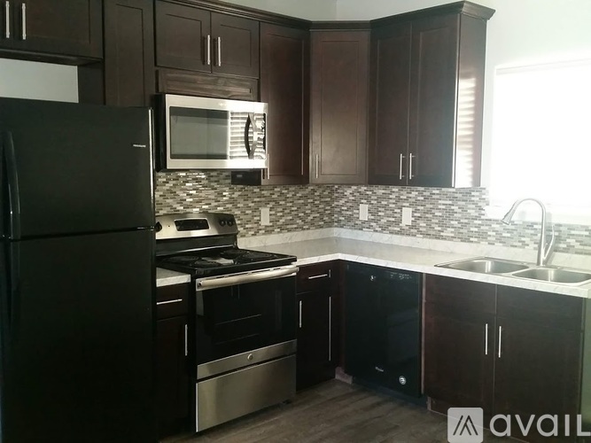 A kitchen with dark wood cabinets and stainless steel appliances.