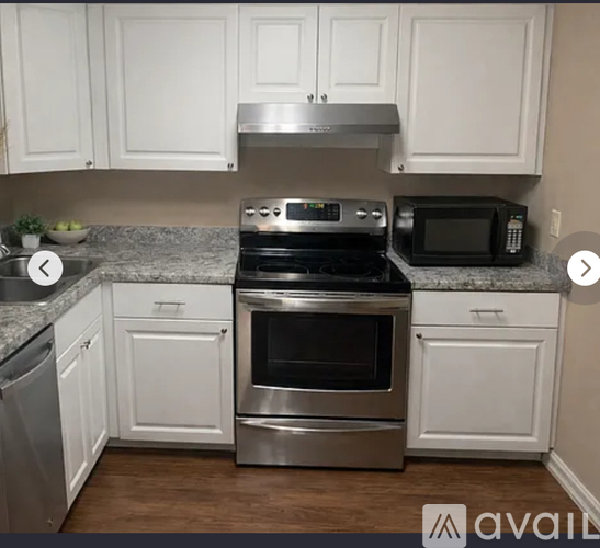 A kitchen with white cabinets and a stainless steel stove top oven.
