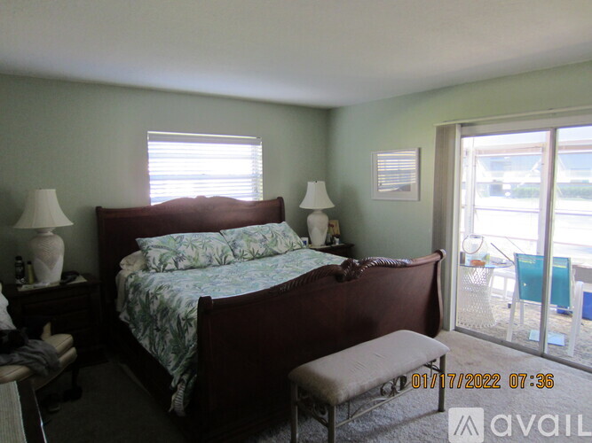 A bedroom with a bed, two lamps, and a bench.