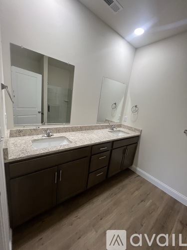 A bathroom with a sink, mirror, and cabinets.