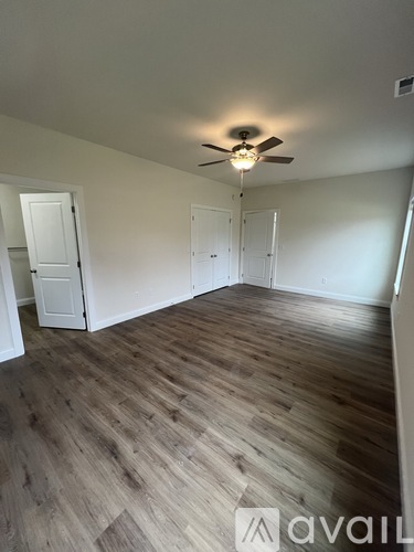 A room with wooden flooring and a ceiling fan.