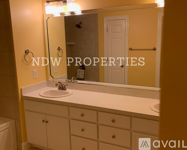 A bathroom with a sink, mirror, and cabinets.