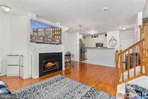 A living room with a fireplace and a painting on the wall.