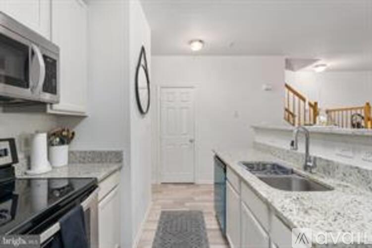A kitchen with a black stove top oven and a white door.