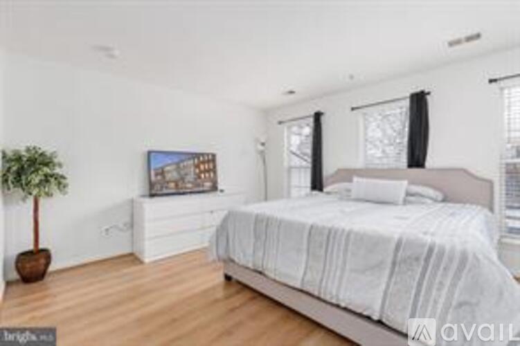 A bedroom with a large bed and a painting on the wall.