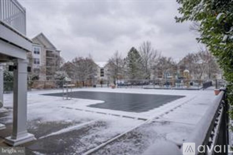 A snow-covered ground with a building in the background.