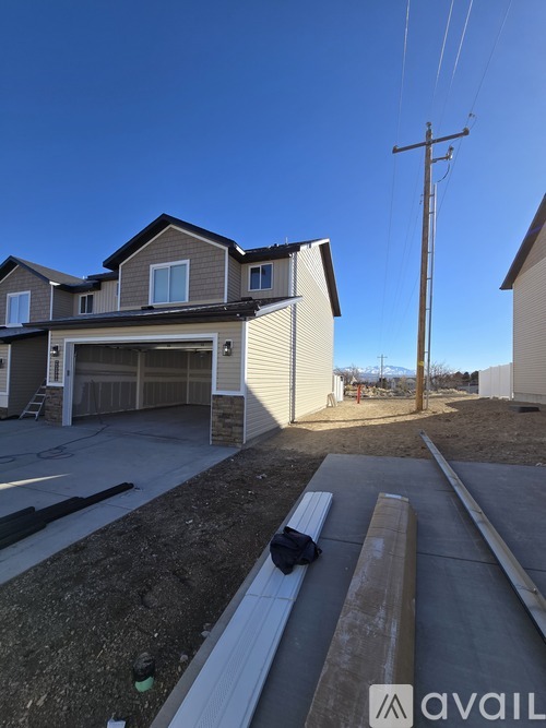 A house with a garage and a driveway in front of it.