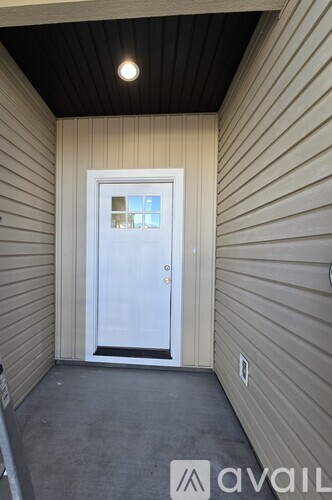 A white door is in the middle of a hallway with beige walls.