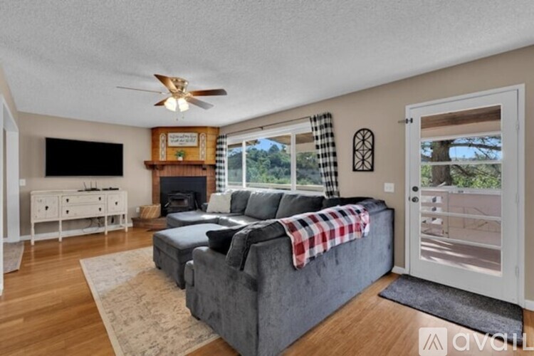 A living room with a grey couch and a fireplace.
