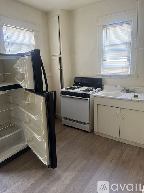 A kitchen with a black fridge, white oven, and a white sink.