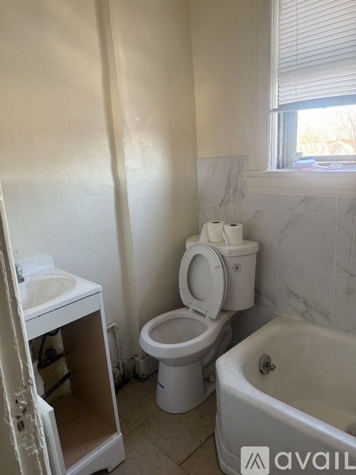 A bathroom with a toilet, sink, and bathtub.