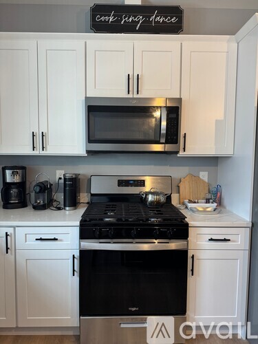 A kitchen with white cabinets and a black stove top.