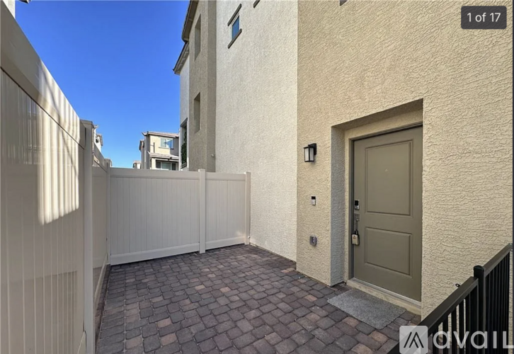 A narrow alley with a white fence and a brown door.
