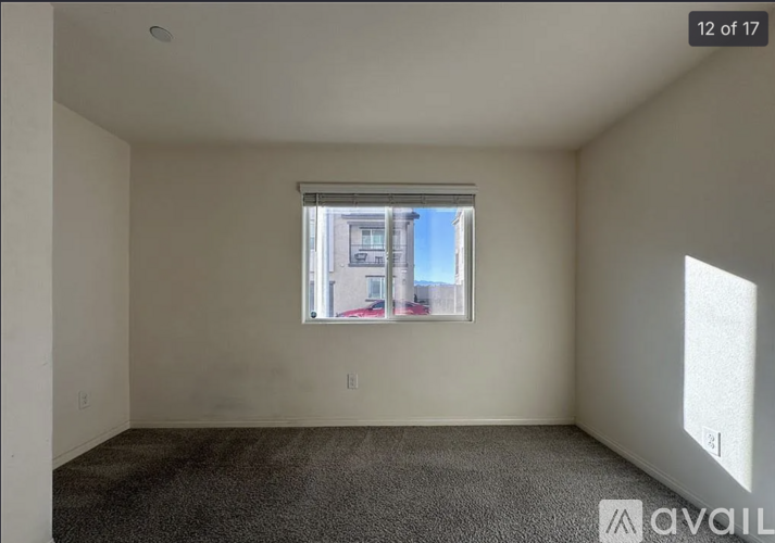 A room with a window showing a view of a building outside.