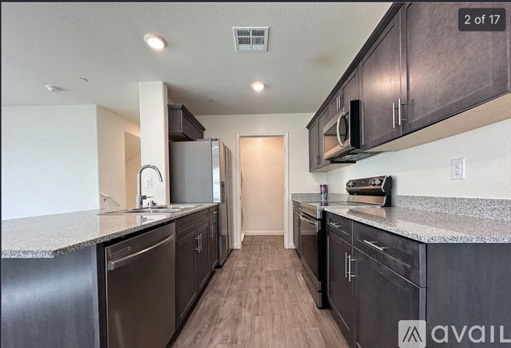 A kitchen with dark wood cabinets and a granite countertop.