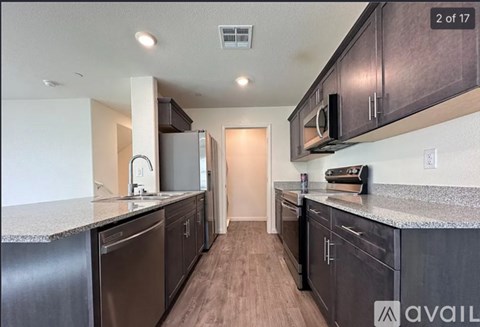 A kitchen with dark wood cabinets and a granite countertop.