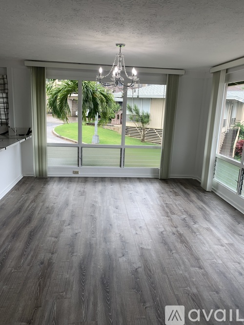 A room with a grey floor and a chandelier.