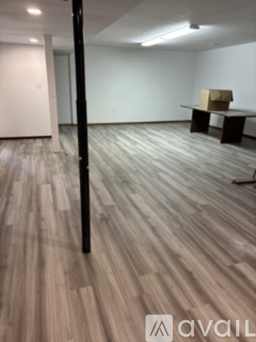 A room with a wooden floor and a box on a table.