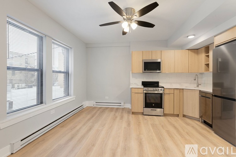 A spacious kitchen with wooden floors and stainless steel appliances.