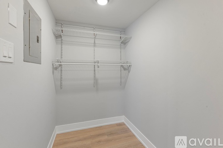 A white wall with a shelf and a light switch.