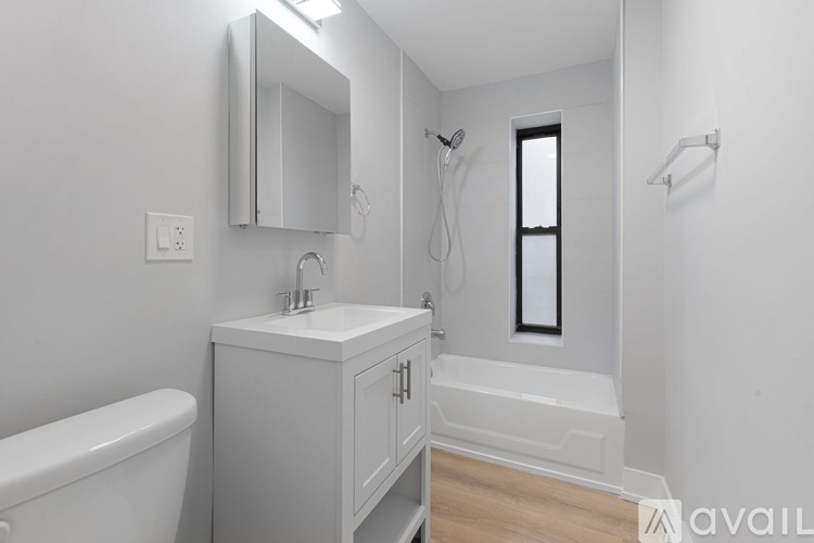 A white bathroom with a tub, sink, and mirror.