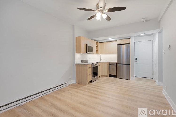 A kitchen with wooden floors and a ceiling fan.