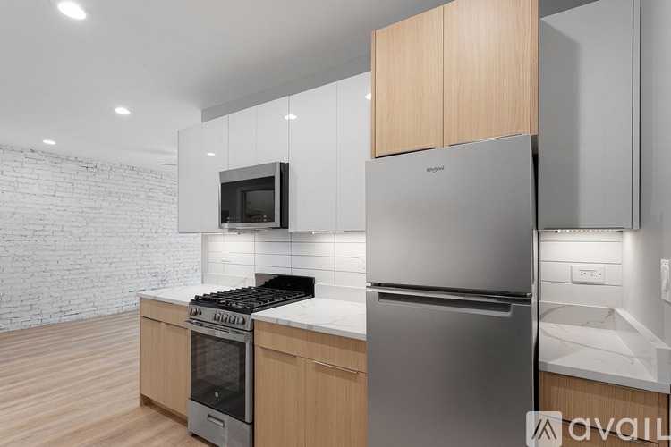 A modern kitchen with a stainless steel refrigerator and oven, and wooden cabinets.