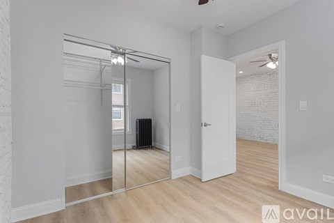 A spacious room with a mirrored door and a radiator.