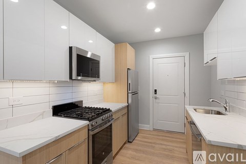A modern kitchen with a stove top oven and a microwave above it.