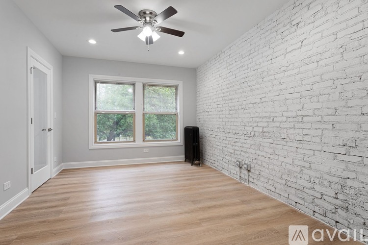 A room with a ceiling fan and wooden flooring.