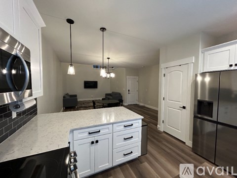 A modern kitchen with white cabinets and a marble countertop.