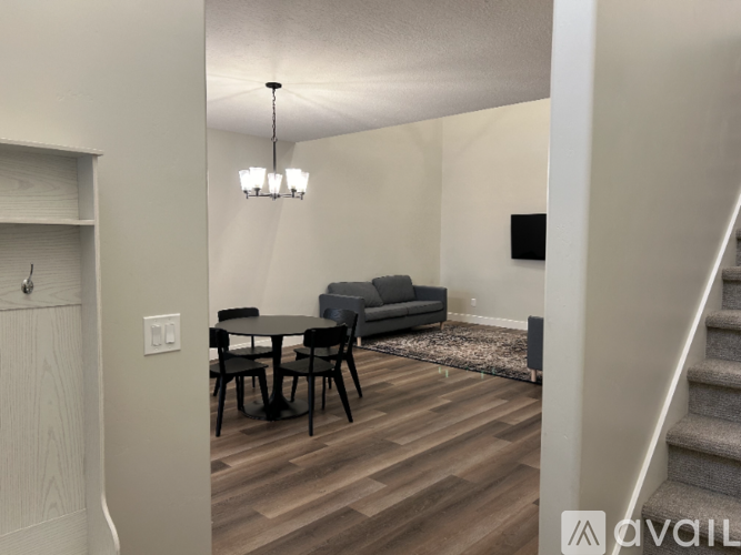 A living room with a grey couch, a black table, and a wooden floor.