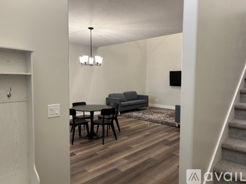 A living room with a grey couch, a black table, and a wooden floor.