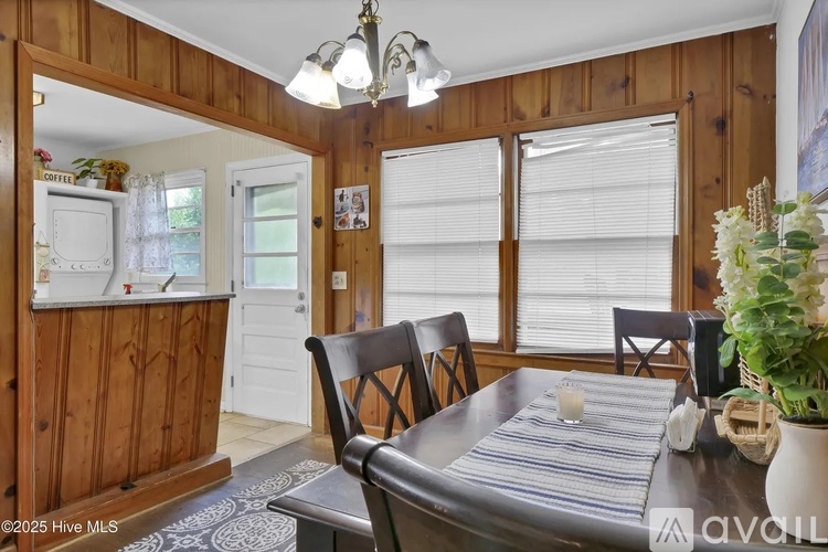 A dining room with a wooden table and chairs.