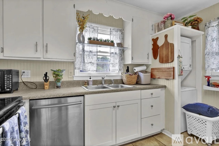 A kitchen with white cabinets and a black microwave.