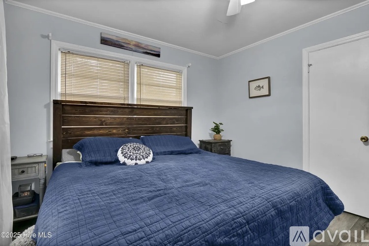 A bedroom with a bed covered in a blue comforter and a white door.