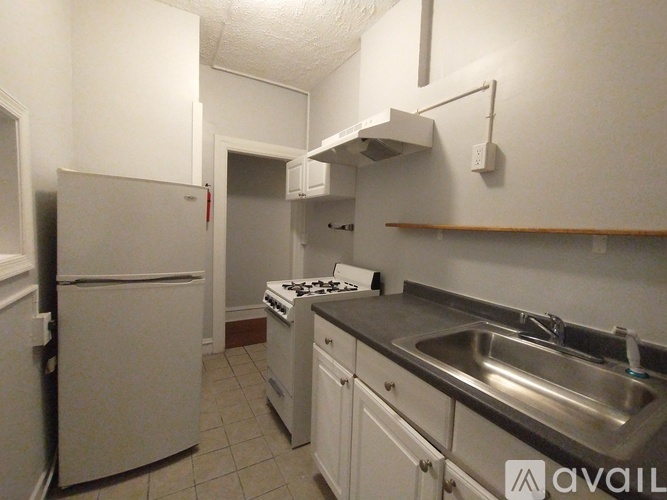 A kitchen with white appliances and a stove top oven.